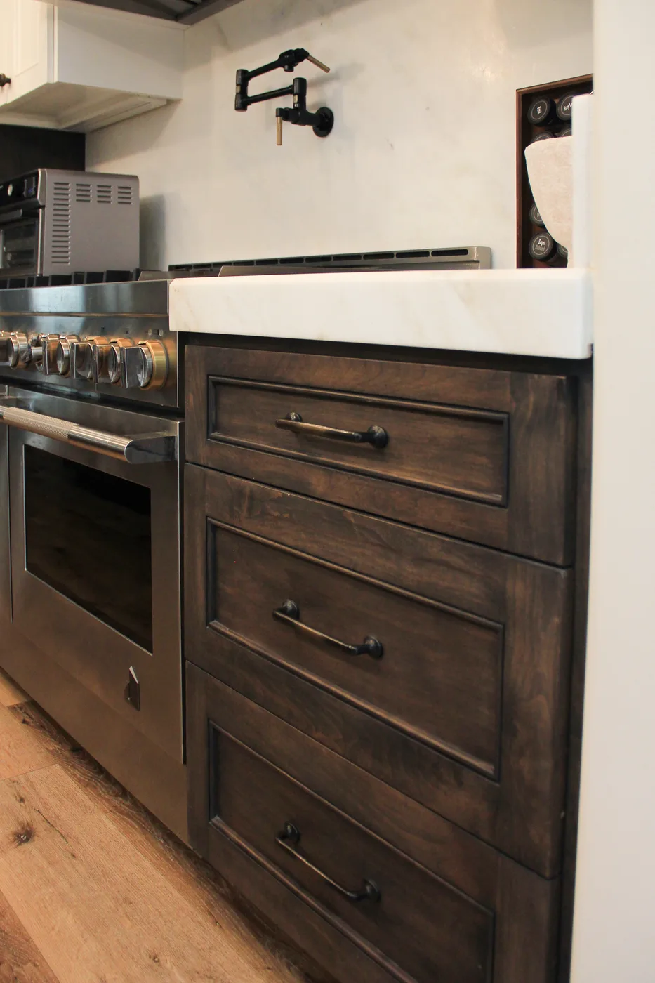 Dark wood inset drawers beside a range