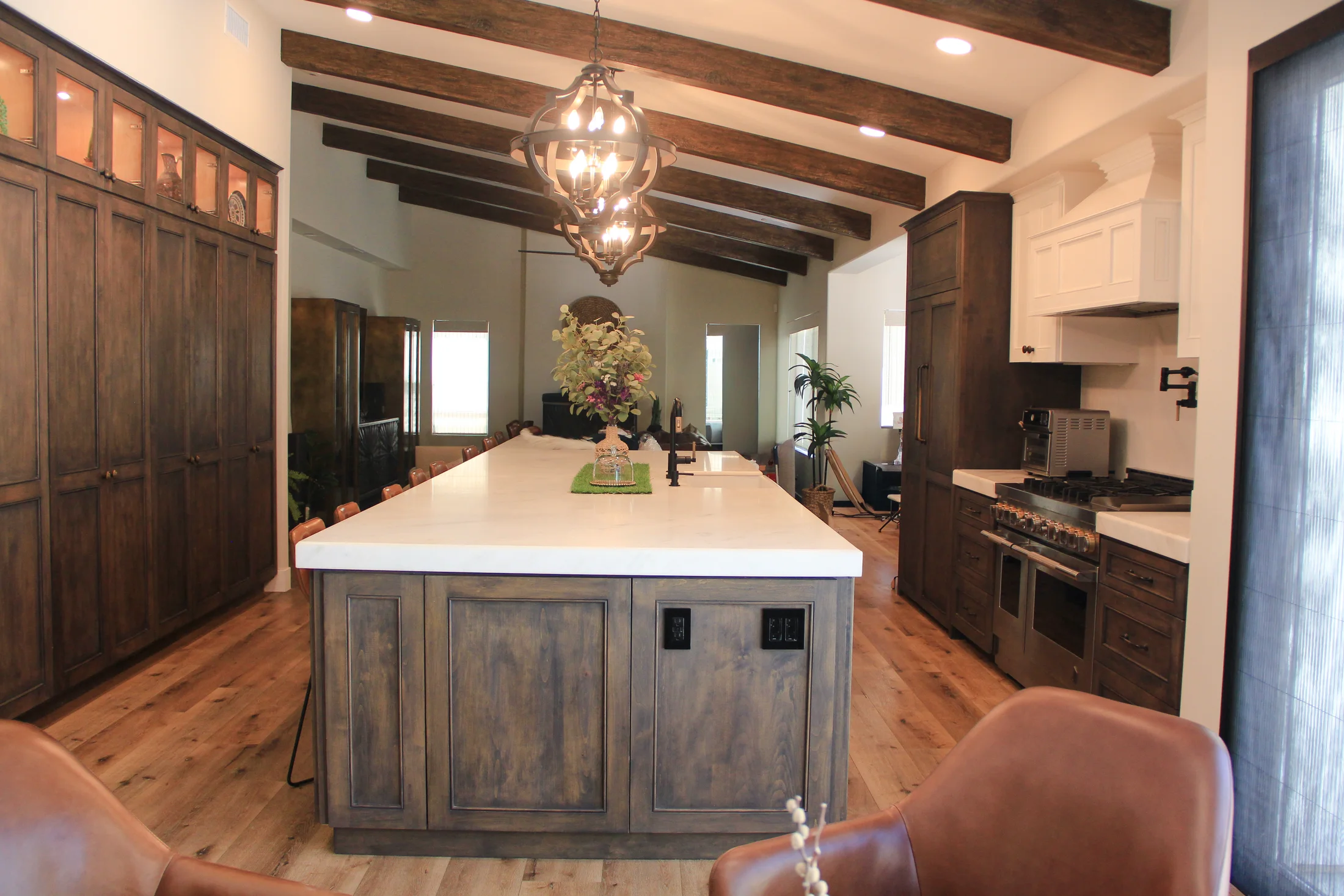 Warm custom kitchen with large island and dark wood cabinetry